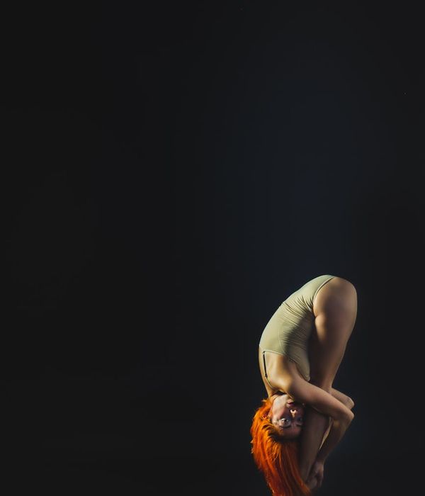 Person performing a stable yoga pose on a dark background